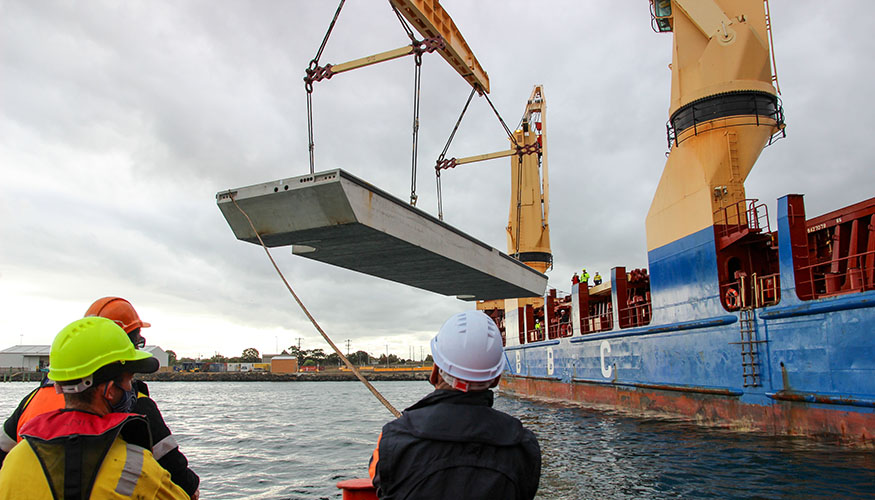 Wave attenuator being unloaded from vessel
